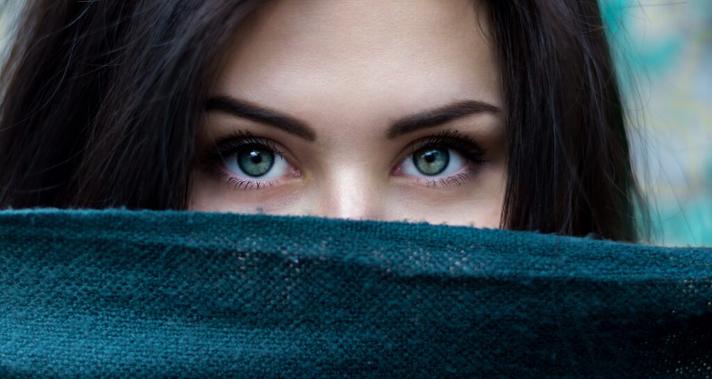 Oczy kobiety zasłoniętej kawałkiem niebieskiego materiału